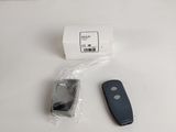 a remote control and a cell phone on a white table