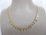 a close up of a gold necklace on a mannequin mannequin