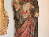 une statue représentant un homme debout près d'un miroir dans une pièce