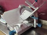 stainless steel counter top with a meat slicer on top of it