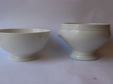 two white bowls sitting next to each other on a table