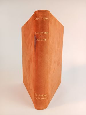 un livre marron ouvert sur une surface blanche