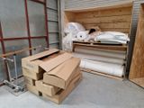 une boîte de papier toilette et une boîte contenant des rouleaux de papier toilette dans un local de stockage