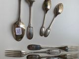 several spoons, forks, and spoons are arranged on a table