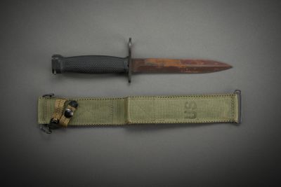 a knife that is laying next to a belt