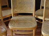 four wooden chairs are lined up in a row on a tile floor