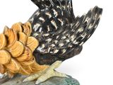 a figurine of a rooster with a pine cone on it ' s head