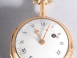 a gold pocket watch with roman numerals on it