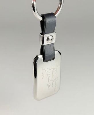 porte-clés en cuir avec une clé plaquée argent et un cordon en cuir noir