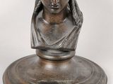 an antique bronze bust of a woman with a wreath on her head
