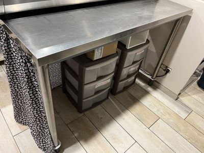 a stainless steel counter with drawers underneath it