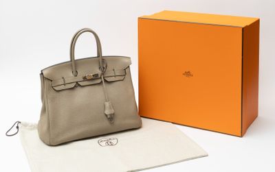 Le sac Hermès est posé à côté d'une boîte orange.