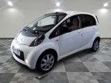 une petite voiture blanche garée dans une pièce