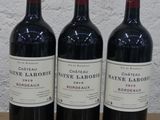 trois bouteilles de vin posées sur une table en bois