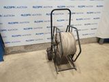 a reel is sitting on a cart in front of a wall