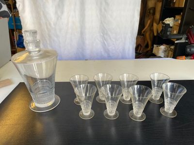 Des bouteilles et des verres sont alignés sur une table à côté d'une carafe.
