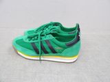 green and black adidas sneakers on a white surface