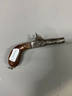un vieux pistolet muni d'une étiquette, accroché au mur