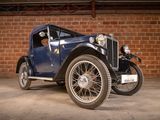 a vintage car that is parked in front of a brick wall