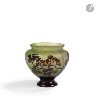 un vase vert orné de fleurs sur fond blanc
