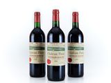three bottles of red wine sitting next to each other on a white surface