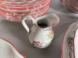 many plates and bowls on the table with a pitcher