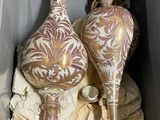 two vases that are sitting on a rock