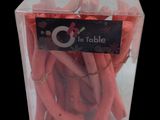 a clear box with a bunch of red hotdogs in it
