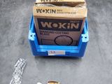 Deux boîtes de Wokin sont posées sur une table, à côté d'une clé à molette.