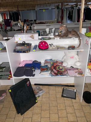 une étagère blanche sur laquelle sont posés de nombreux objets, dans une pièce