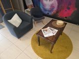 deux chaises et une table dans une pièce où est accroché un tableau au mur