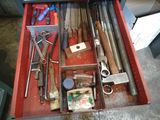 une boîte à outils rouge remplie d'outils divers, posée par terre