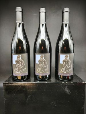 trois bouteilles de vin posées sur une caisse en bois