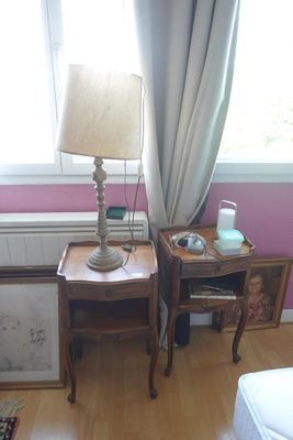 une petite table sur laquelle est posée une lampe, à côté d'un lit