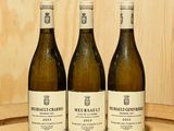 trois bouteilles de vin posées sur un tonneau en bois