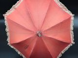 a red umbrella with a white lace trim on it