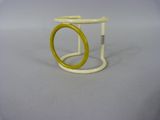 un anneau jaune et blanc posé sur un socle blanc
