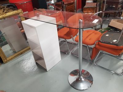 une table en verre avec des chaises orange dans un magasin