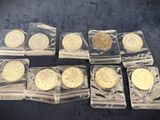 six different types of gold coins in plastic containers on a table