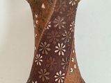 a brown vase with flowers on it sitting on a table