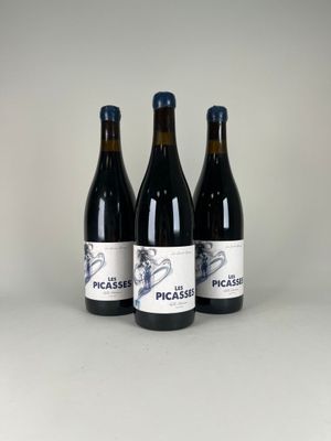 trois bouteilles de vin posées l'une à côté de l'autre sur une table