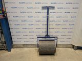 the floor roller is sitting in front of a wall with a sign on it