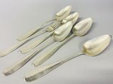 six silver spoons and two silver spoons sitting on a table