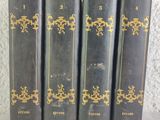 quatre vieux livres sont alignés sur une surface blanche