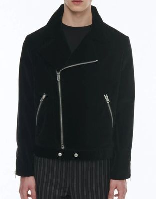 the man is wearing a black jacket and striped pants