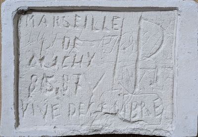 un gros plan d'une plaque en pierre sur laquelle figurent des inscriptions