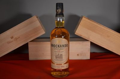 a bottle of whisky sitting on a table next to a wooden box