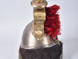 a silver helmet with a red feather on top of it