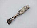 a silver spoon on a white plate with a silver handle