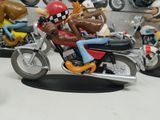 toy figurines of a man riding a motorcycle with a dog on the back